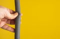 Against the yellow background the hands of a plumber are testing the integrity of a drain pipe: they highlight a crack that caused