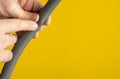 Against the yellow background the hands of a plumber are testing the integrity of a drain pipe: they highlight a crack that caused Royalty Free Stock Photo