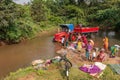 Red tractor with kids, women doing laundry in creek, Agalkera, Karnataka, India