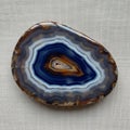 Agate is placed on a textured, light-colored fabric, providing a neut Royalty Free Stock Photo