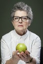 Age, healthy eating, food, diet and people concept - close up of happy smiling senior woman with green apple Royalty Free Stock Photo