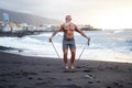 Senior man with white stylish beard exercising on the beach. Summer vacation workout Royalty Free Stock Photo