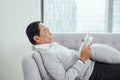 Age, leisure and people concept - senior man lying on sofa and reading book at home Royalty Free Stock Photo