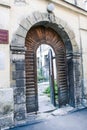 Age-old Wooden Door in Oval Stone Arch Open into Yard