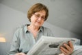 age and people concept - happy senior woman reading newspaper at home Royalty Free Stock Photo