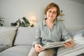 age and people concept - happy senior woman reading newspaper at home Royalty Free Stock Photo