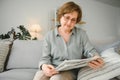 age and people concept - happy senior woman reading newspaper at home Royalty Free Stock Photo