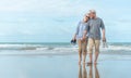 Age, Travel, Tourism and people concept - happy senior couple holding hands and walking on summer beach Royalty Free Stock Photo