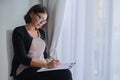 Age woman social worker, psychologist sitting near the window with clipping board Royalty Free Stock Photo