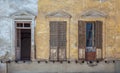 Aged abandoned vintage grunge house facade with broken windows and weathered shutters