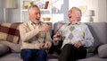 Aged brothers laughing sitting sofa together, old friends having fun, free time Royalty Free Stock Photo