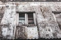 Aged building with dirty walls and broken window in Stone Town, Zanzibar. Weathered facade of abandoned house.