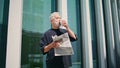 Aged businessman drinking coffee at downtown. Thoughtful senior read newspaper Royalty Free Stock Photo