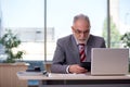 Aged businessman employee working in the office Royalty Free Stock Photo