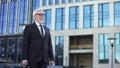 Aged businessman standing outdoors office center, waiting taxi, unpunctuality Royalty Free Stock Photo