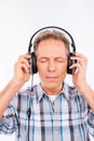 Aged calm hipster with headphones listening to music