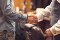 Aged client handshaking with barber in the barbershop