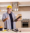 Aged contractor repairman working in the kitchen