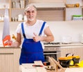 Aged contractor repairman working in the kitchen