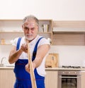 Aged contractor repairman working in the kitchen