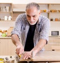 Aged contractor repairman working in the kitchen