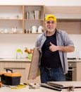 Aged contractor repairman working in the kitchen