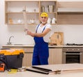 Aged contractor repairman working in the kitchen