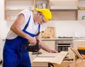 Aged contractor repairman working in the kitchen