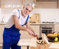 Aged contractor repairman working in the kitchen