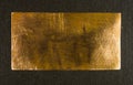 Aged copper plate on black cloth, old worn metal background. Royalty Free Stock Photo