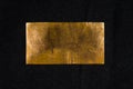 Aged copper plate on black cloth, old worn metal background. Royalty Free Stock Photo