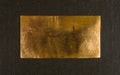 Aged copper plate on black cloth, old worn metal background. Royalty Free Stock Photo