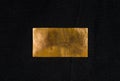 Aged copper plate on black cloth, old worn metal background. Royalty Free Stock Photo