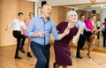 Aged couple dancing jive during group training