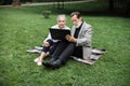 Aged couple sitting on blanket at park and using laptop Royalty Free Stock Photo