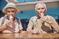 Aged couple sitting at a wooden table Royalty Free Stock Photo