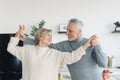 Aged couple smiling and dancing in kitchen together Royalty Free Stock Photo