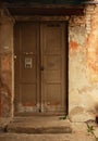 Aged dark wooden door in weathered dirty brick wall Royalty Free Stock Photo