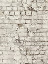 An aged and dilapidated brick wall with crumbling white paint, showcasing the weathered and textured surface caused by