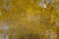 Aged  dirty bright yellow concrete wall with cracks, scratches, peeling gray and white paint and dark mold stains. rough surface Royalty Free Stock Photo