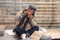 Aged homeless begger eating bread on the bridge Royalty Free Stock Photo