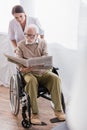 Disabled man reading newspaper in wheelchair Royalty Free Stock Photo