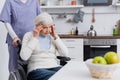 aged disabled woman touching head while