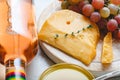 Aged dutch gouda cheese on cheeseboard with cumin herbs on table. Cheddar cheese with grapes, pink wine, honey. Wine