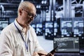 Aged engineer coding in data center Royalty Free Stock Photo
