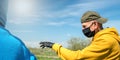 Aged farmer in disposable mask and gloves talks to friend