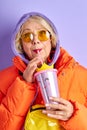 Aged fashionable woman in casual fancy warm wear drinking juice