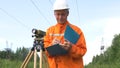 Aged geodesist looks through dumpy level binocular and notes