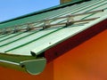 aged green weathered copper plate sloped roof. aluminum snow and ice breaker. rain water gutter Royalty Free Stock Photo