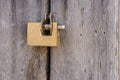 Aged grunge gold lock pad on vintage ancient wooden door Royalty Free Stock Photo